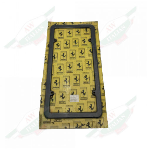 Black plastic rectangle wrapped in plastic with yellow cardboard background on white background