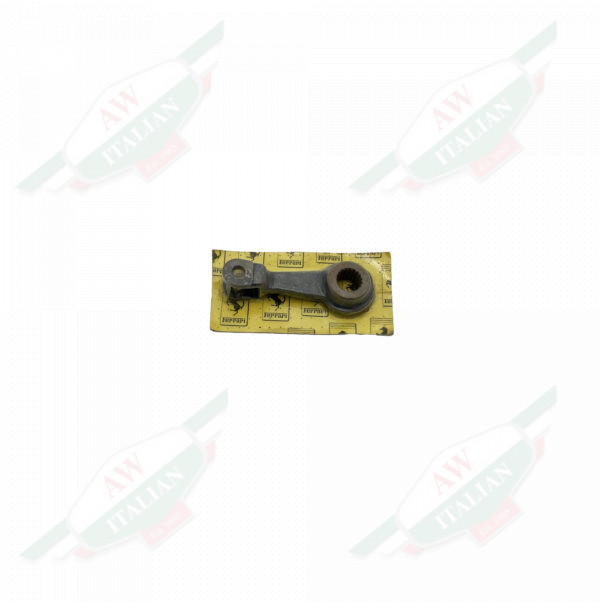 Dark metal piece wrapped in plastic with a yellow cardboard backing on a white background