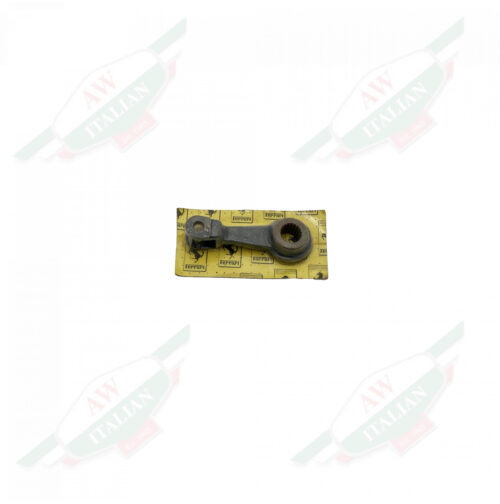 Dark metal piece wrapped in plastic with a yellow cardboard backing on a white background